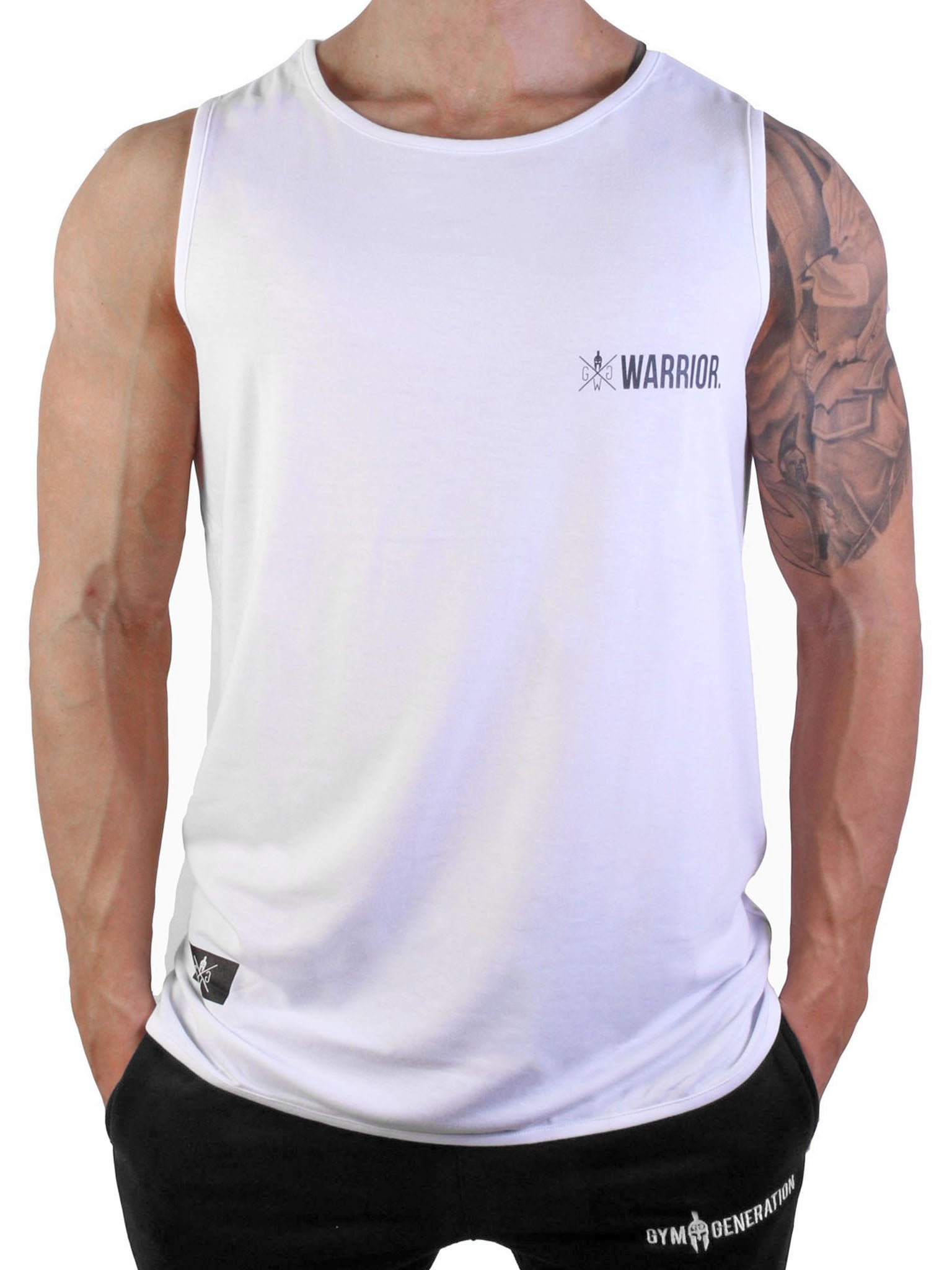 Fitnessmodel trägt das Gym Generation Fitness Tank Top 'Warrior' in Weiß, mit Warrior-Logo auf der Brust, und eine sportliche Hose von Gym Generation.