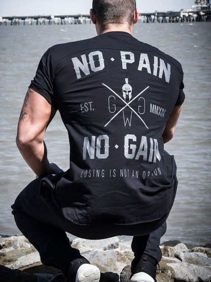 Rückenansicht des Gym T-Shirts 'No Pain No Gain' in Schwarz von Gym Generation, getragen an einem Strand mit dem markanten Druck 'No Pain No Gain' und 'Losing is Not an Option'.