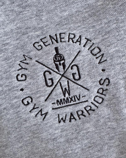 Gym Generation Logo-Stick in Schwarz auf grauem Stoff – hochwertiges Detail der Fitness Shorts Legacy.