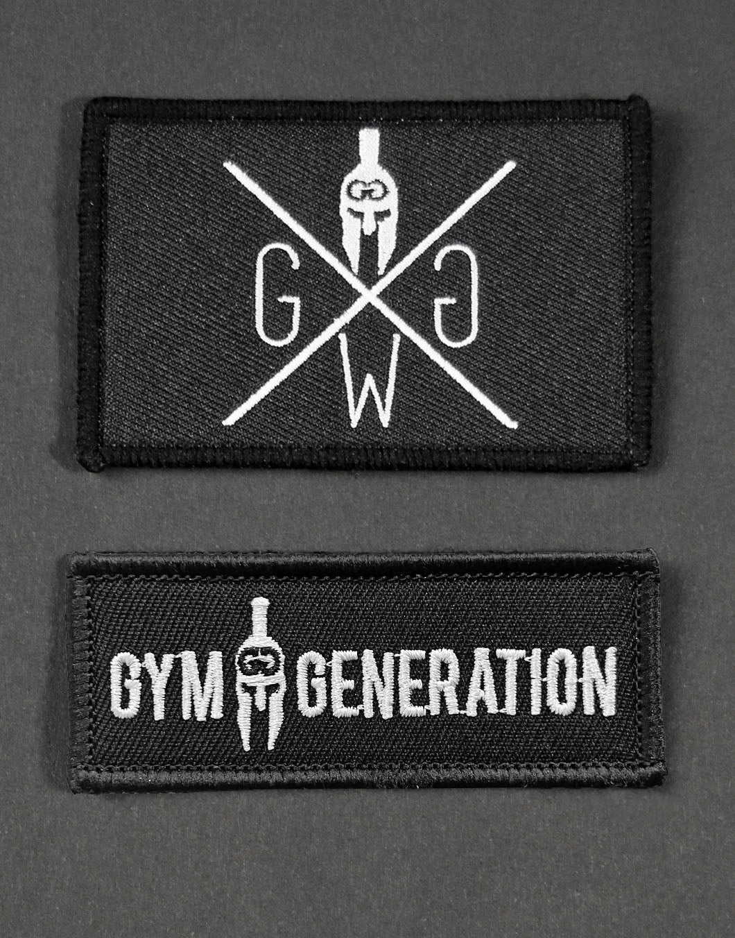 Zwei hochwertige Gym Generation Patches in Schwarz mit präziser Stickerei – eines mit stilvollem Logo-Design und eines mit dem Schriftzug „Gym Generation“. Ideal für die Individualisierung von Rucksäcken, Kleidung und Accessoires, perfekt für Sport und Alltag.