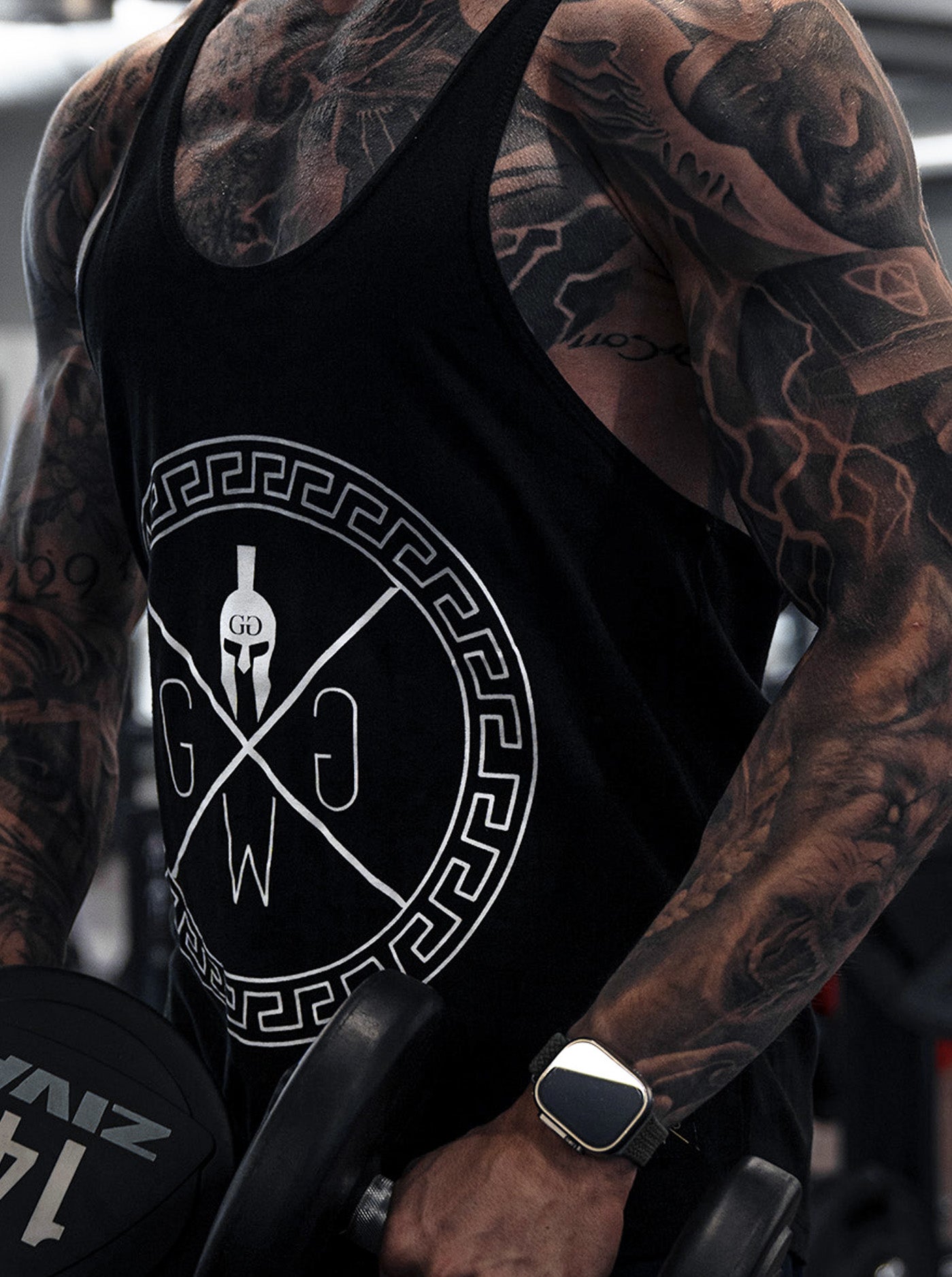 Fitness Stringer Tank – Schwarzes Tank Top von Gym Generation, mit ikonischem Spartaner-Logo und maximalem Tragekomfort für Training und Alltag.