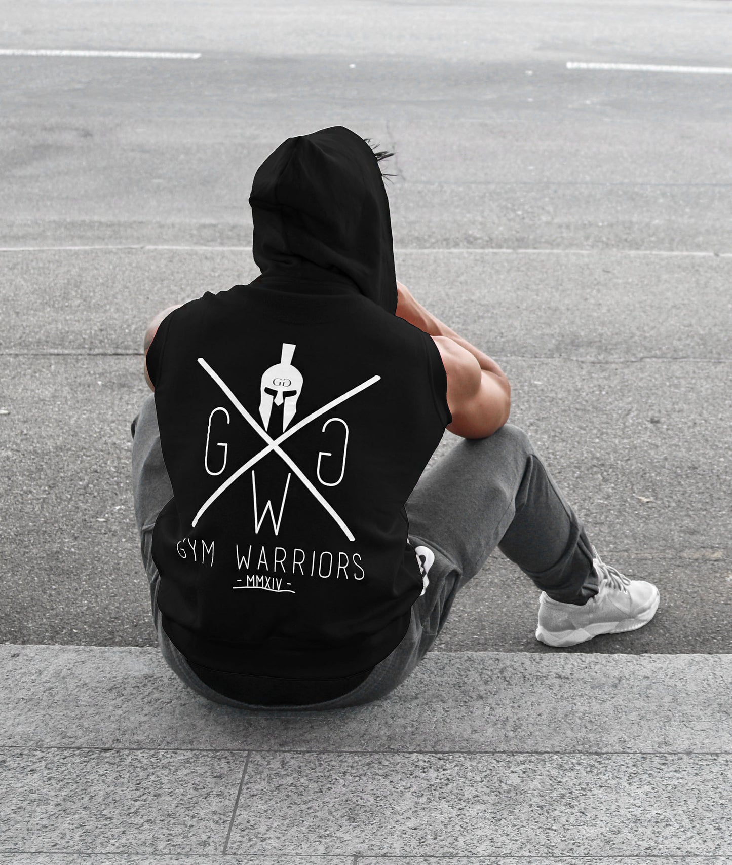 Sitzende Rückansicht des ärmellosen Gym Generation Hoodies in Schwarz mit Gym Warriors Logo, perfekt für Training und Freizeit.






